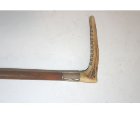 CHILDS HUNTING WHIP with a carved handle and silver mounted collar. 42cms long