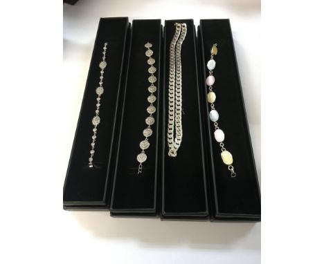 Three boxed bracelets set with CZ and enamel, and one boxed silver curb chain.