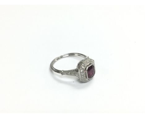 A platinum ring set with a step cut ruby and R/C diamonds. Ruby approx 0.87ct, diamonds approx 0.20ct, approx 4.2g and approx