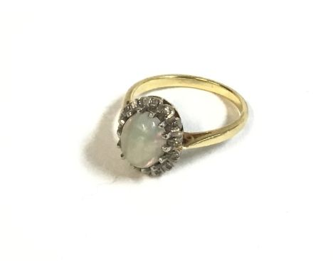 An 18ct gold ring set with opal and diamond chip ring. Size N and 4.3g Postage A