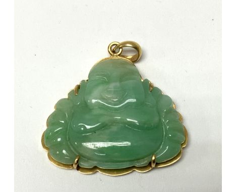A 14ct yellow gold and carved apple green jade Buddha pendant. (A)