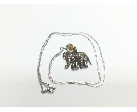 An elephant pendant in yellow and white metal set with a ruby eye and R/C diamonds on a silver chain. Diamonds approx 0.63ct,