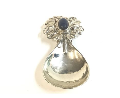 An Omar Ramsden silver caddy spoon. London 1927 spot hammered fig shaped bowl. The terminal with pierced and wire work decora