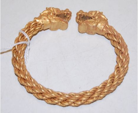 A modern Chinese gilt metal bangle, each terminal in the form of a dragons head