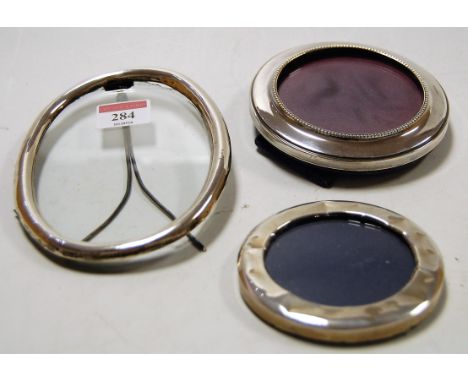 A plain silver oval easel photograph frame; together with two circular examples (3)