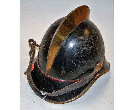 An early 20th century continental Adrian pattern helmet having a brass comb, lion's head ear bosses, and leather chinstrap (l