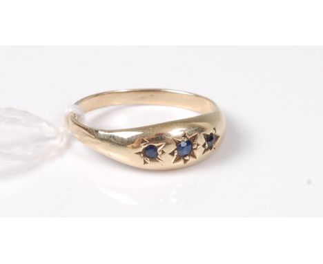 A 9ct sapphire ring, the three gypsy set sapphires, in a plain tapering band hallmarked Birmingham 1988, size O, (1.9g)