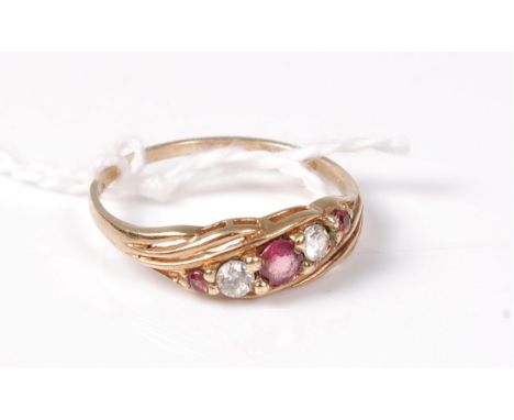 A 9ct five stone ruby and diamond ring, set asymetrically to tapering reeded shoulders and plain band, hallmarked London 1969