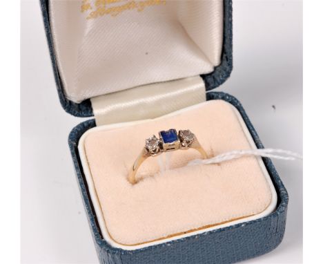 A sapphire and diamond ring, the central square sapphire set to either side with a single rose cut diamond, all set in white 