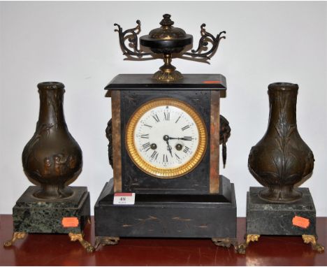 A late Victorian black slate mantel clock having enamelled dial with Roman numerals and eight day movement, the whole surmoun