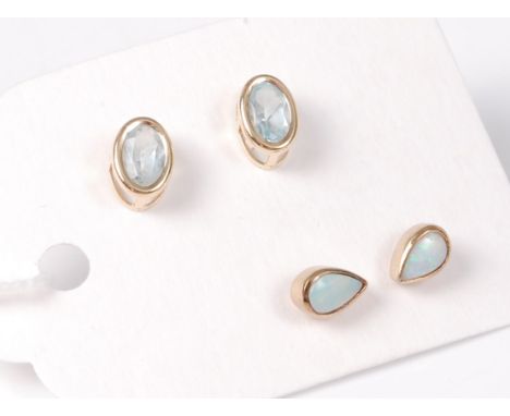 A pair of oval aquamarine earstuds, 6.8mm long, and a pair of pear shaped opal earstuds, 5.8mm long, both in rubover mounts o