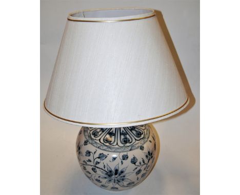 A large modern table lamp of globular form having all over floral decoration on cream ground with silk shade