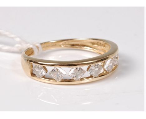 A 14ct CZ ring, the seven CZ's channel set to a plain tapering band, hallmarked Birmingham 2003, size O, (2g)