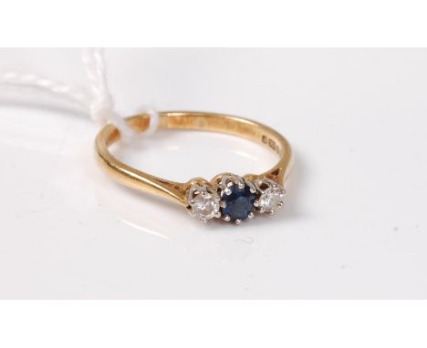 An 18ct sapphire and diamond ring, the round sapphire set to either side with a round briliant cut diamond, total estimated a