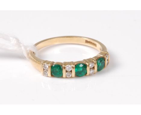 An 18ct green hardstone and diamond ring, the round green hardstones set to either side with two small round brilliant cut di