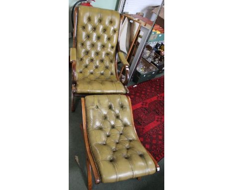A green button backed leather armchair with matching foot stool.