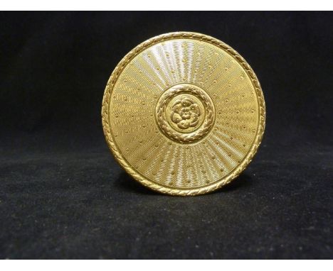 A gilt metal circular box and cover in French Empire style, decorated with a central rosette within a laurel wreath borders o