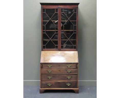 A George III and later mahogany bureau bookcase, the dental moulded cornice above two astragal glazed doors over a fall front