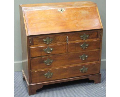 A George III mahogany bureau with brass handles and attachments, the lower section with three long and two short drawers, 100