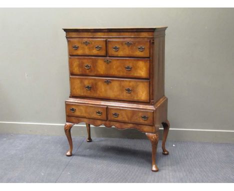 A George II style figured walnut chest on stand with six drawers over shell carved cabriole legs supports, 132 x 95 x 47cm