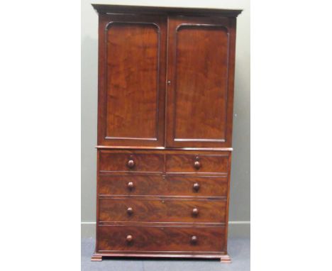 A 19th century mahogany linen press, the dental moulded cornice over panelled cupboard doors enclosing three slides, the lowe