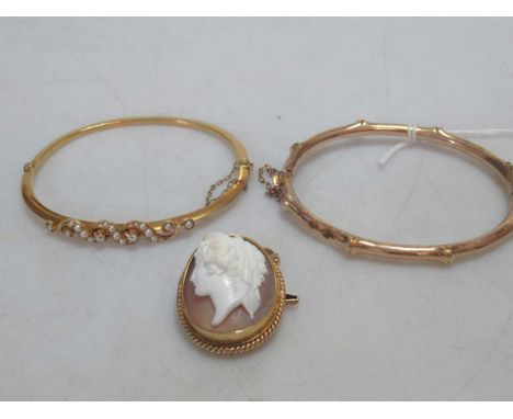 A pearl and diamond bangle, tested as 9ct gold, together with a hallmarked 9ct gold bangle and a cameo brooch tested as 9ct g
