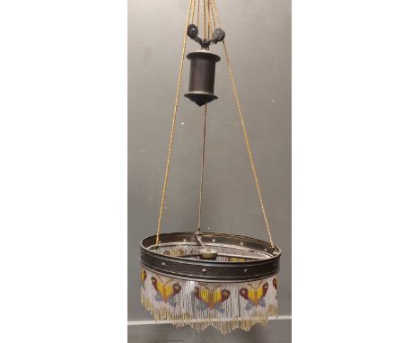 A brass counterweight lamp shade with beaded details 47cm wide; together with an art deco style metal mirror decorated with t