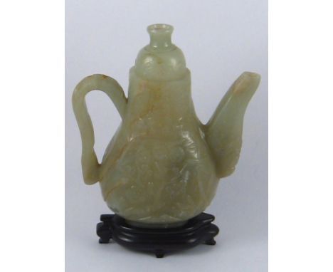 A carved Chinese green jade pot on hardwood stand. ht. 16cm. 