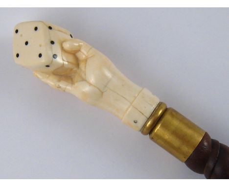 A Victorian walkng stick, the shaft tightly turned spiral hardwood, the handle a hand holding a gaming die. 