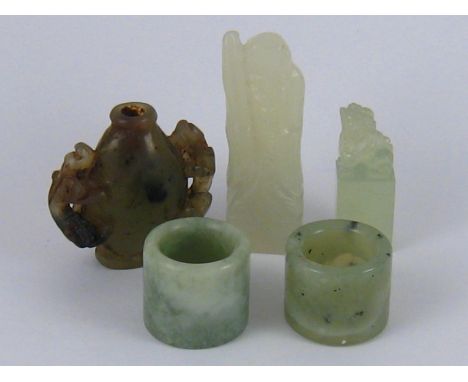 Two Chinese archer's rings, a carved jade snuff bottle and two carved seals, one a temple lion, the other a sage. 