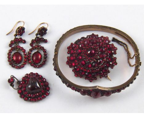 A mixed lot of antique “Bohemian garnet” jewellery comprising a bangle, a brooch, a pair of earrings and a heart pendant.
