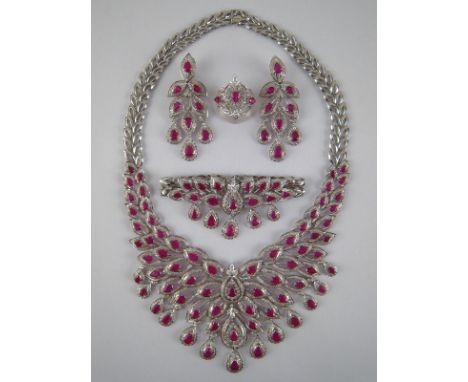 A white metal (tests 18 carat gold) ruby and diamond parure comprising necklace, earrings, ring and bracelet, the necklace me