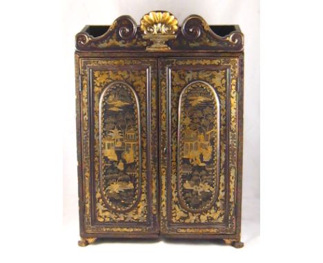 A Chinese lacquered cabinet on claw feet, the black surface with gilt domestic and landscape scenes within borders of butterf