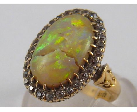 A yellow metal (tests 18 carat gold) opal and diamond ring (opal cracked), ring size G, 5.4 gms.