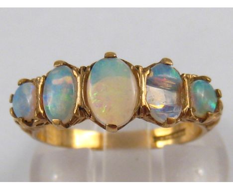 A 9 carat gold five stone opal ring (one stone damaged), largest opal approx. 6.5 x 4.5mm, ring size O, 2.8 gms.