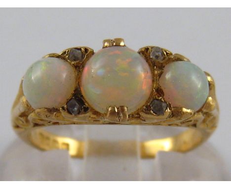 An 18 carat gold opal and diamond ring, the principal opal measuring approx. 5.5mm diameter, ring size I, 4 gms.
