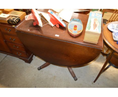 A reproduction mahogany drop leaf table