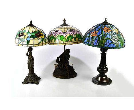 Three bronzed lamps two modelled as maidens, each with Tiffany style lamp shades, height of largest 63cm.