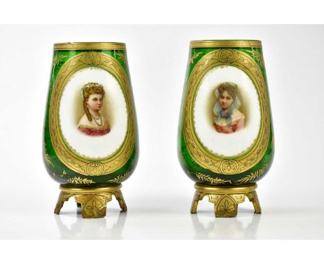 A pair of late 19th century Bohemian green glass vases, each with hand painted opaque panels, portraits of maidens inside a g