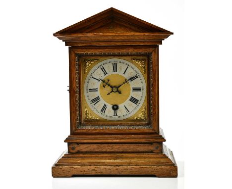 A late 19th/early 20th century oak mantel clock of architectural form, the dial set with Roman numerals, height 29cm.