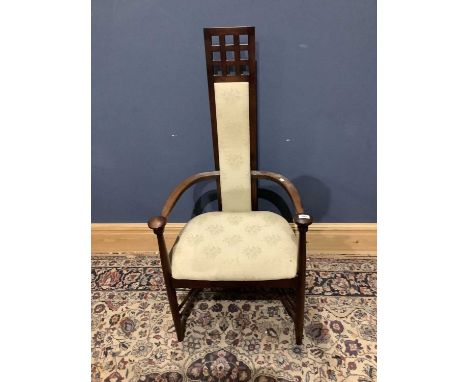 An arts &amp; crafts style elbow chair with floral tapestry back and seat.