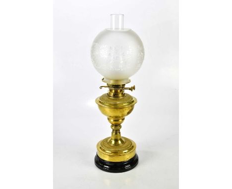 A Victorian brass oil lamp on an Art Nouveau style column with black gloss round ceramic base, with twin wick burner, the gal