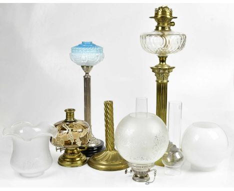A Victorian brass oil lamp, with milk glass shade and faceted reservoir on a Corinthian column, height 77cm, together with tw