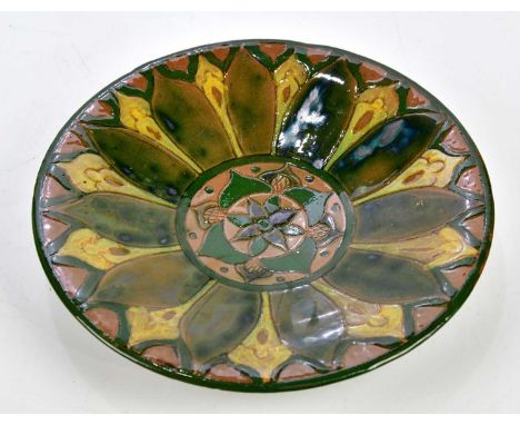 HANNAH JONES FOR DELLA ROBBIA POTTERY; a footed dish with sgraffito and painted stylised floral decoration, diameter 24cm.Con