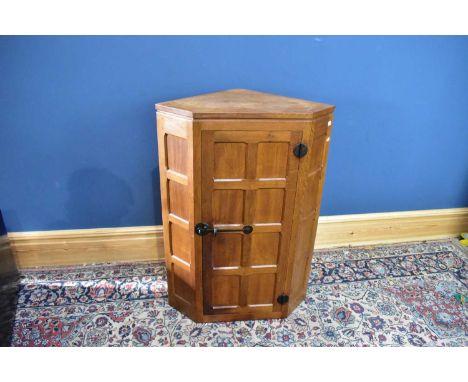 WORKSHOP OF ROBERT 'MOUSEMAN' THOMPSON; a light oak corner cupboard with single panelled door, height 100cm.