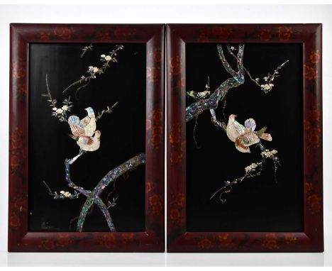 A pair of early 20th century Japanese lacquered panels, with mother of pearl inlaid decoration depicting exotic birds and pru