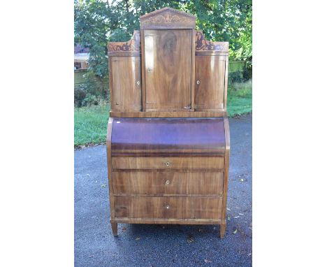 A 19th century mahogany Biedermeier roll-top bureau bookcase, the upper section of architectural form inlaid with stylised fi