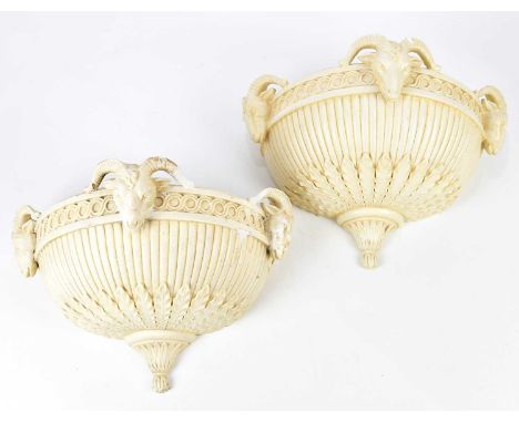 A pair of decorative plaster wall light shades decorated with rams' heads, width 40cm, height approx. 26cm.