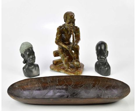 A circa 1950s carved African bowl of oval form, length 44cm, together with a pair of hardstone African figures and a similar 