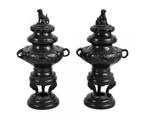 A pair of Japanese Meiji period bronze koro and covers of typical form with Dogs of Fo finials and embossed decoration depict